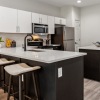 Spacious and well lit kitchen with wood floors and stainless steel appliances 